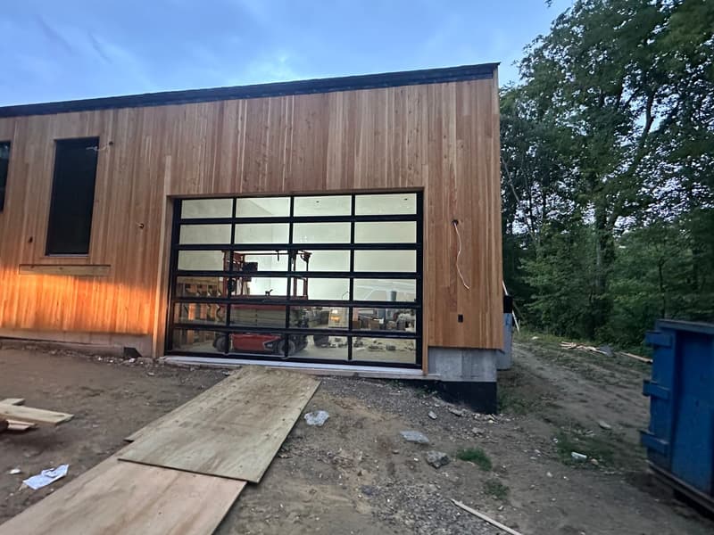 Modern full-view glass garage door on a Massachusetts home